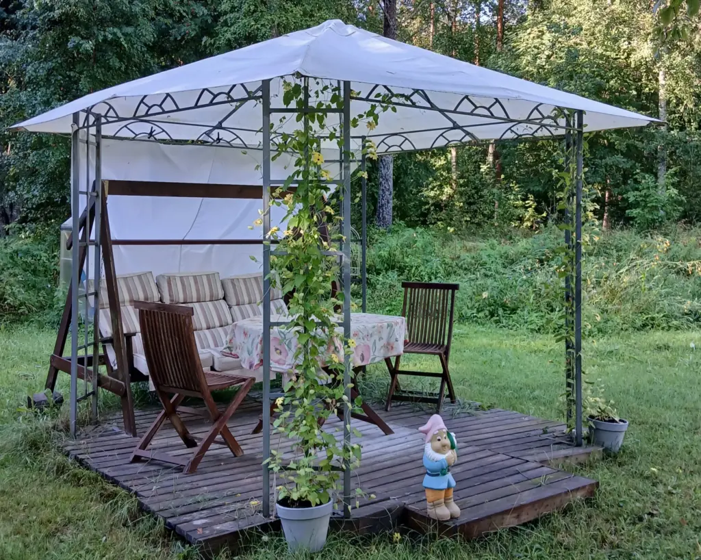 viihtyisä terassi pihalla tuolit, pöytä ja keinu