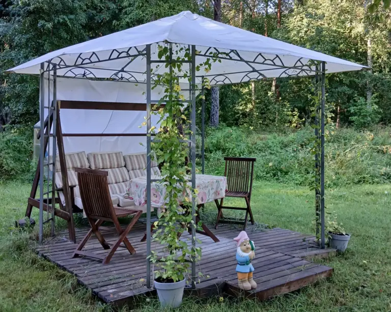 viihtyisä terassi pihalla tuolit, pöytä ja keinu